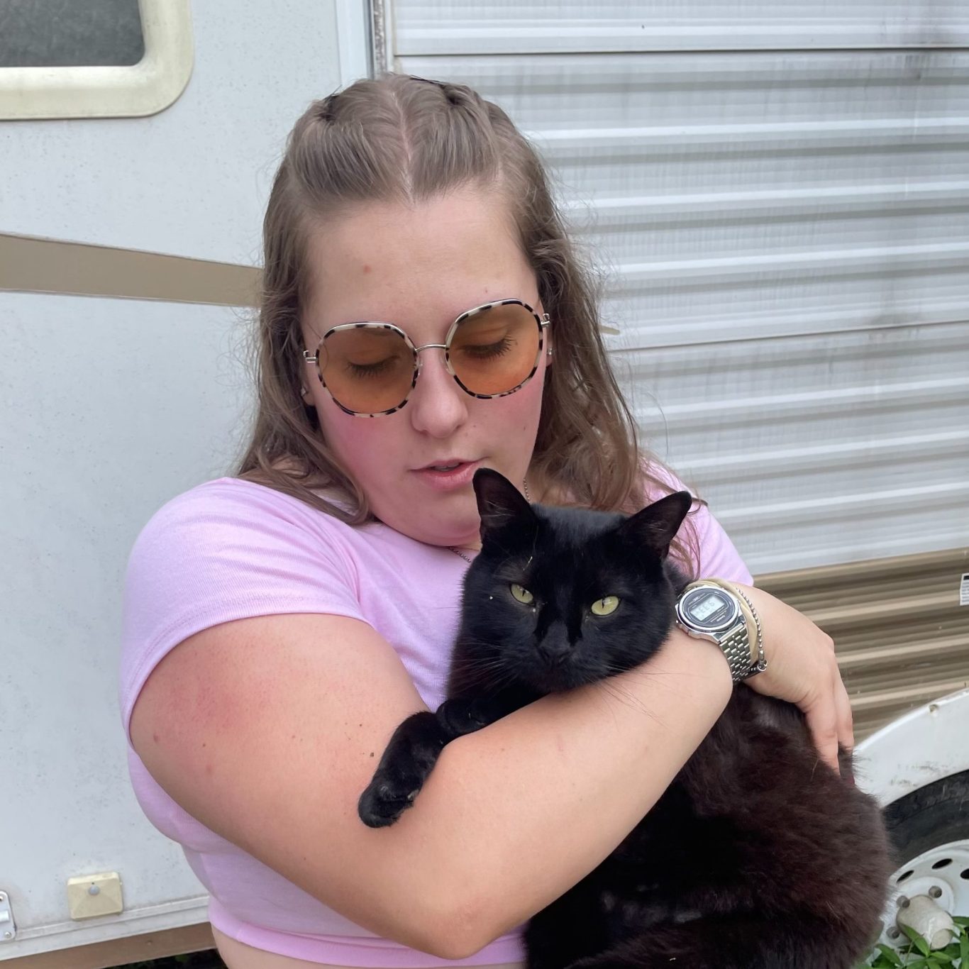 Rachael A photo of Rachael Lauren holding a docile black cat. She is a caretaker.